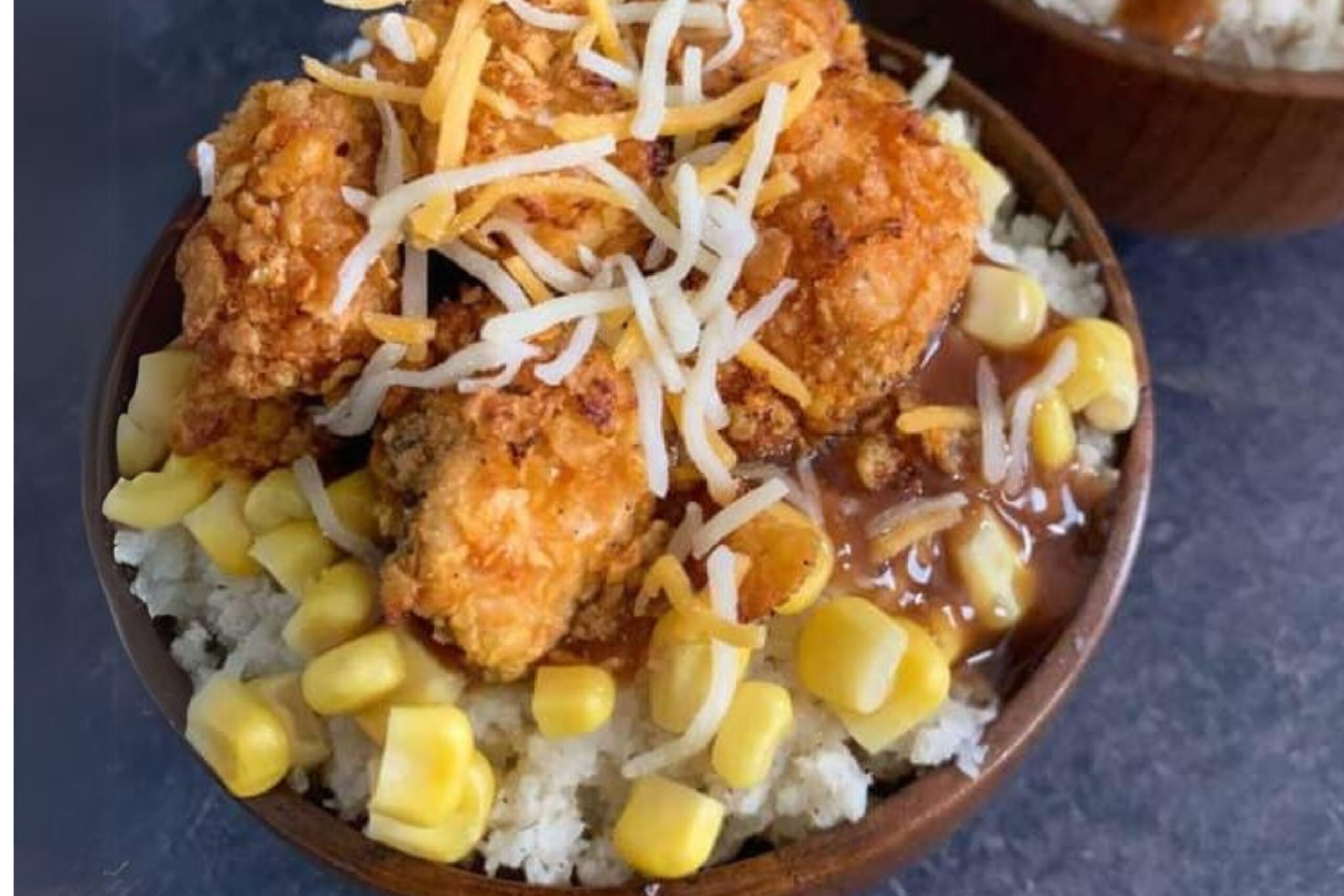 Ingredients for KFC bowl, including mashed potatoes, chicken, corn, and cheese.