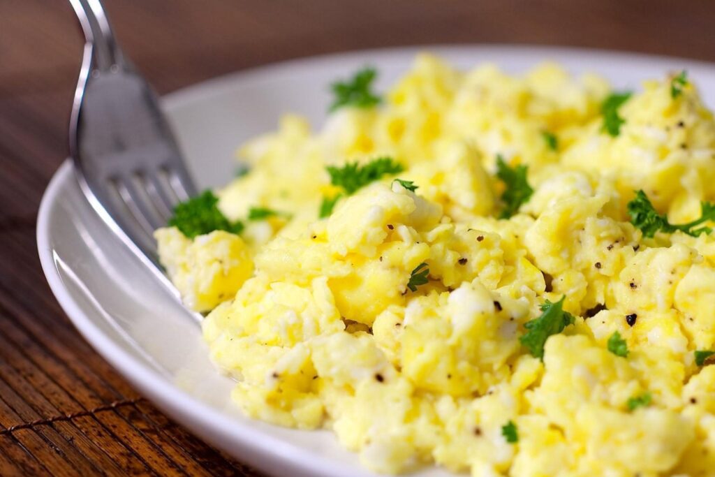 Fresh eggs and a whisk ready for fluffy scrambled eggs