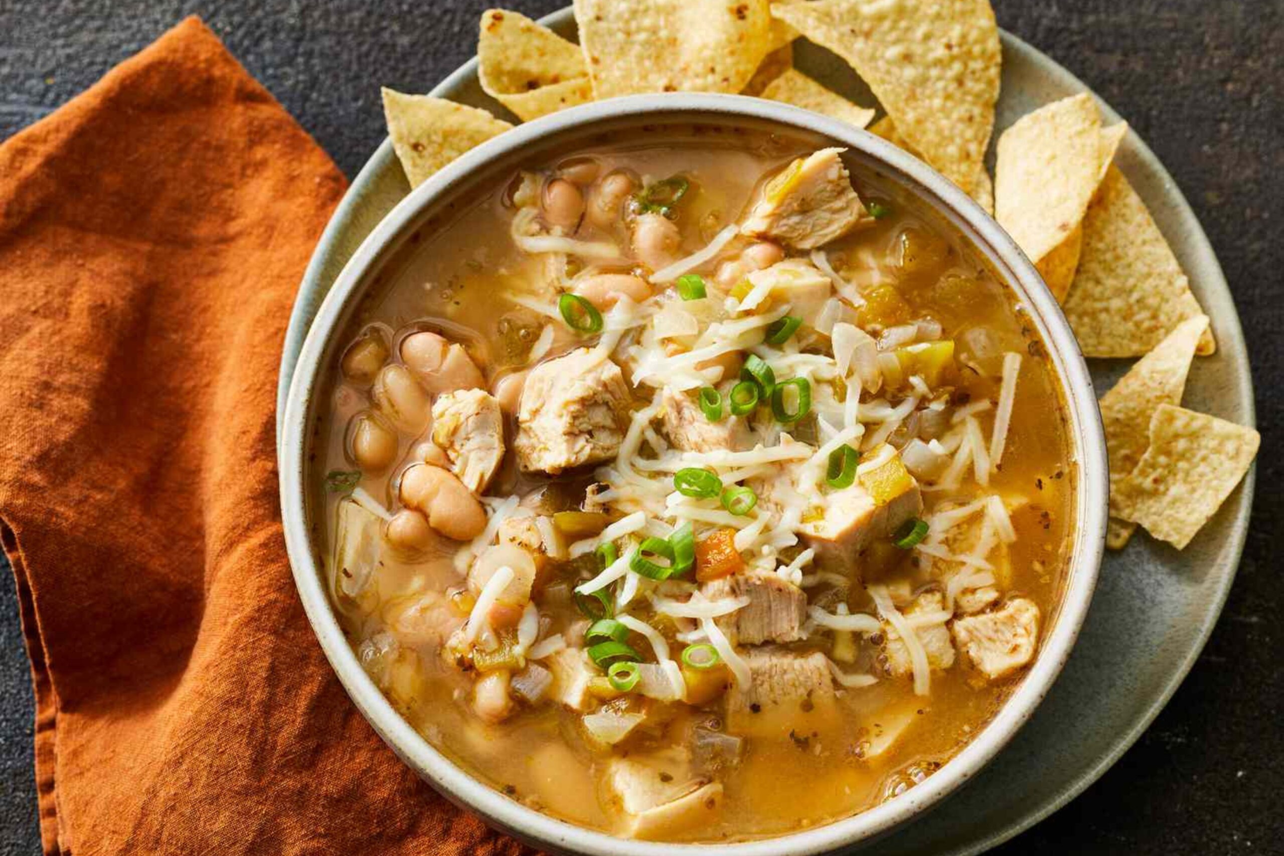 Bowl of creamy white chicken chili topped with fresh cilantro and shredded cheese