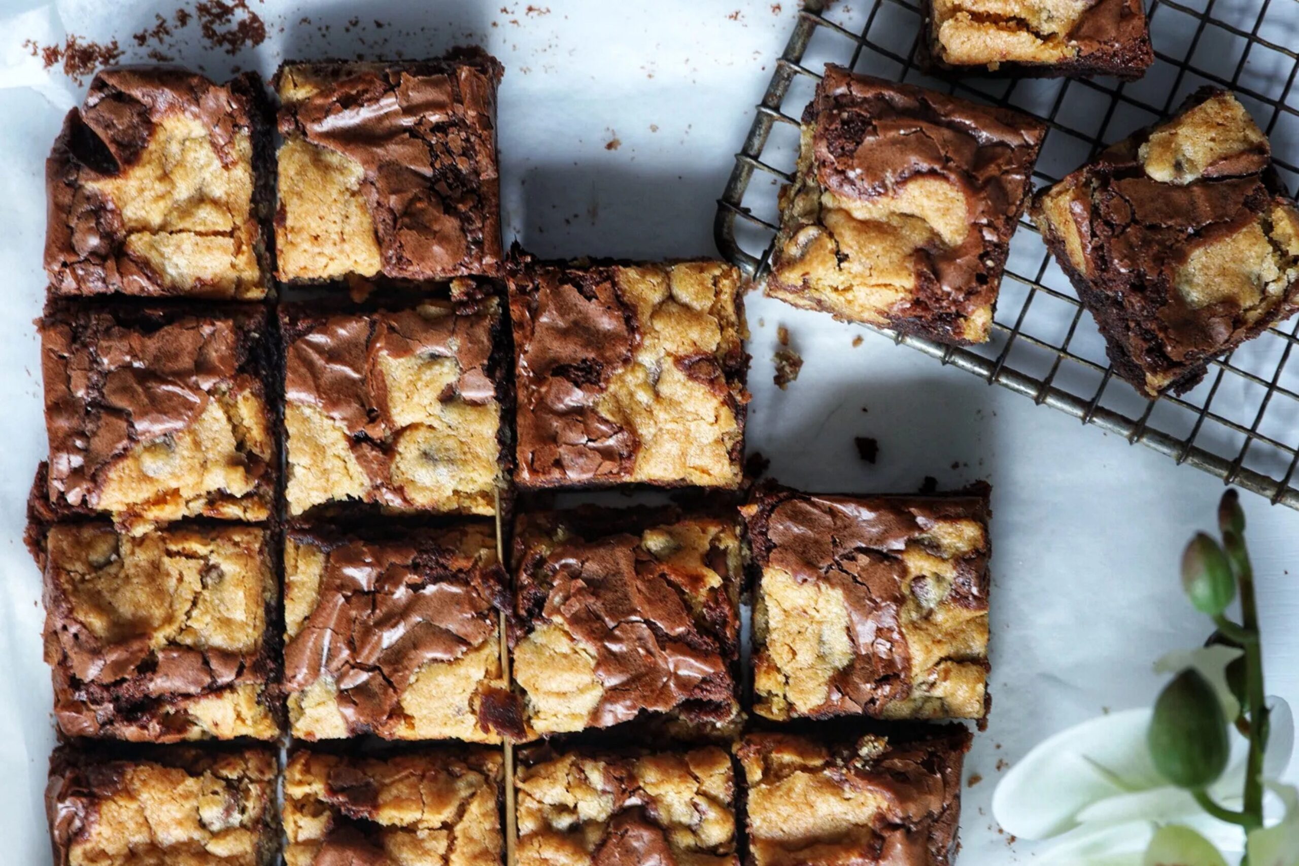 A slice of brookie featuring a rich brownie base topped with golden, chewy cookie dough, served on a stylish dessert plate.